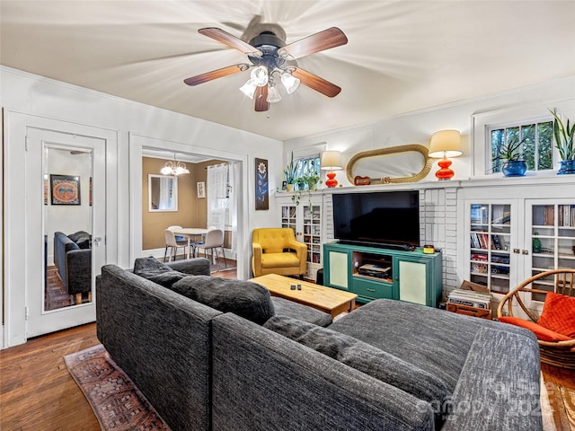 living room with wood finished floors and ceiling fan with notable chandelier