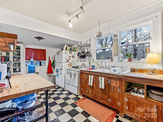 kitchen featuring white appliances, ornamental molding, tile patterned floors, rail lighting, and a sink