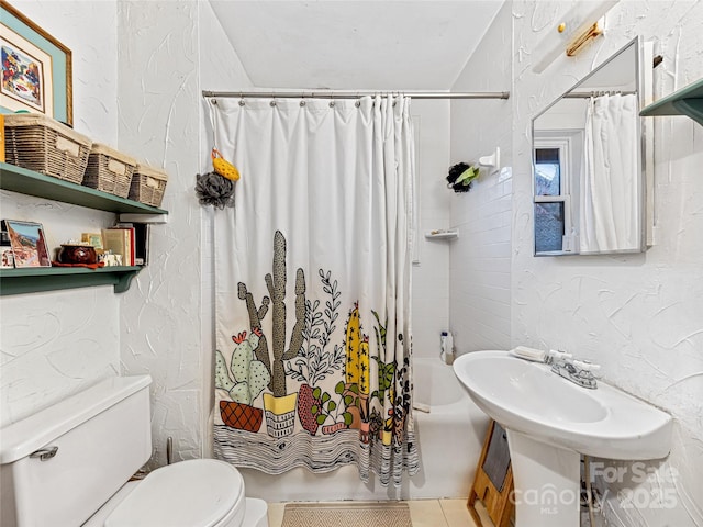 bathroom featuring toilet, shower / bathtub combination with curtain, and a textured wall