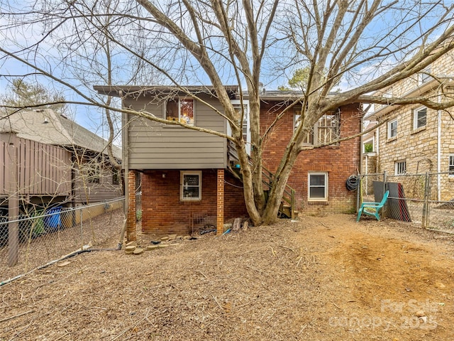 back of property with brick siding and fence