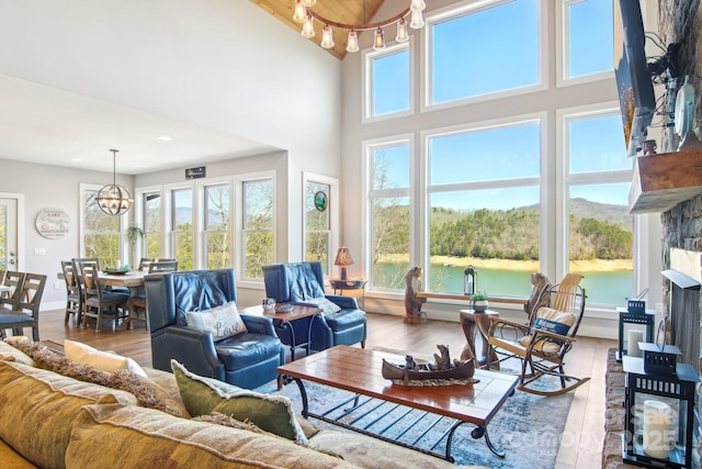 living area with a healthy amount of sunlight, a notable chandelier, and wood finished floors