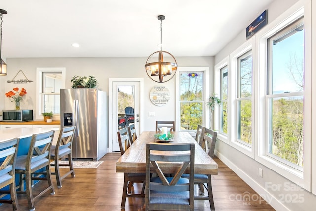 dining space with a chandelier, dark wood-type flooring, recessed lighting, and baseboards