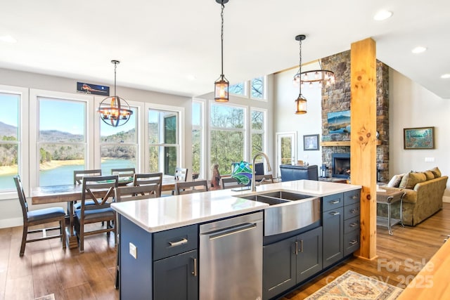 kitchen featuring dark wood finished floors, dishwasher, open floor plan, light countertops, and a sink