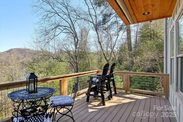 wooden terrace featuring a forest view