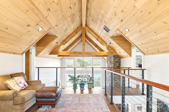 living area featuring lofted ceiling with beams, wood finished floors, and wood ceiling