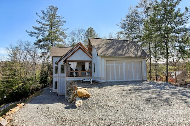 view of front facade featuring a garage, driveway, and roof with shingles