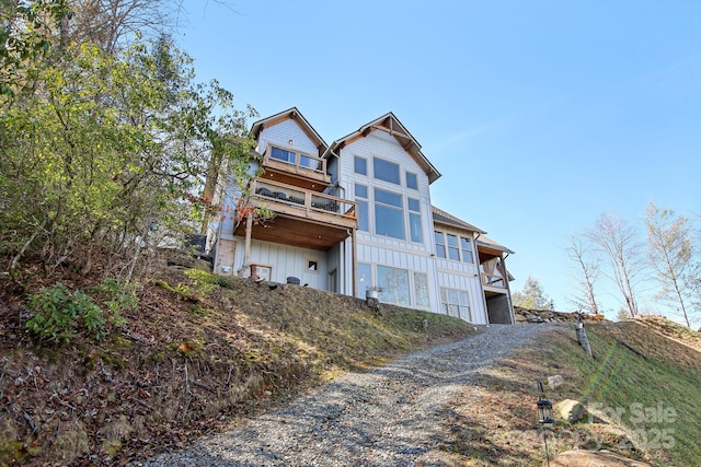 rear view of house with driveway and a balcony