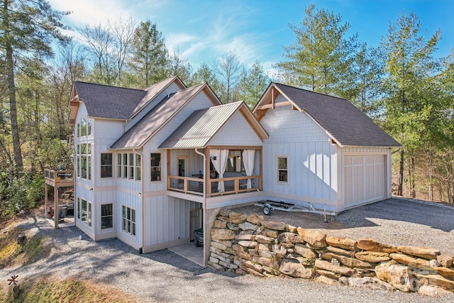 back of property featuring a sunroom, a shingled roof, and board and batten siding