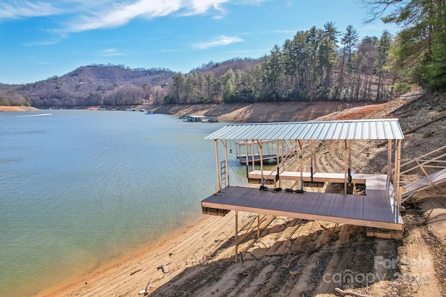 dock area featuring a water view and a wooded view