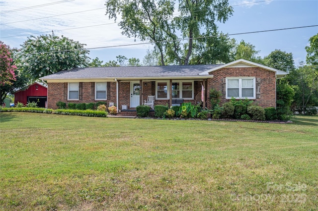 ranch-style home featuring brick siding and a front lawn