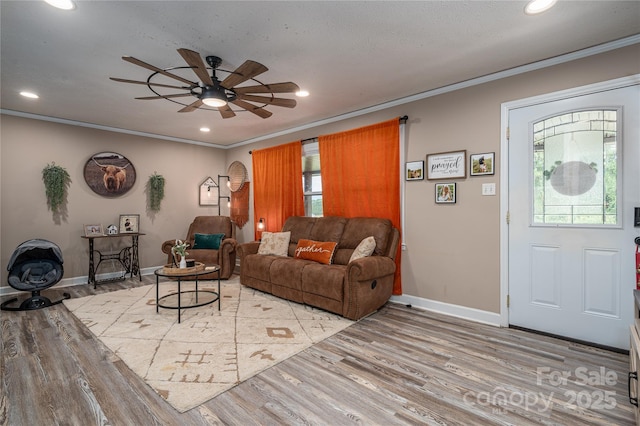 living room with ceiling fan, recessed lighting, baseboards, light wood finished floors, and crown molding