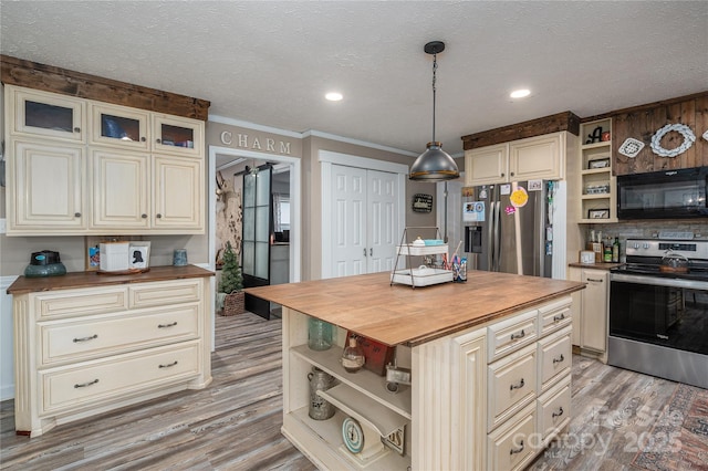 kitchen featuring cream cabinetry, open shelves, butcher block counters, light wood-style flooring, and appliances with stainless steel finishes