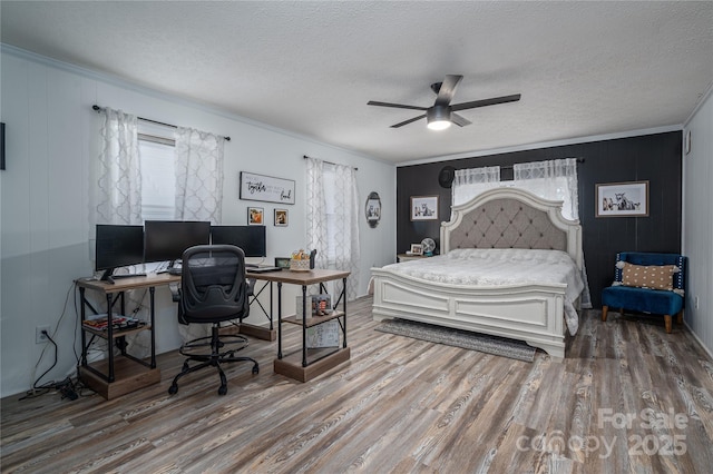 bedroom with ornamental molding, a textured ceiling, and wood finished floors