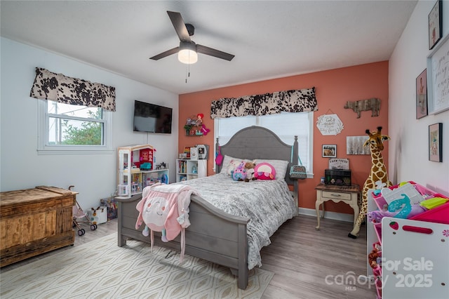 bedroom with ceiling fan, baseboards, and wood finished floors