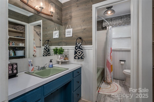 bathroom featuring toilet, shower / bath combination with curtain, and vanity