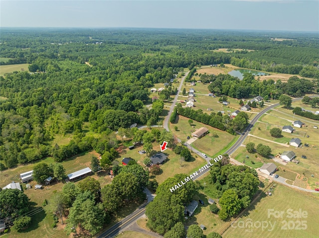 birds eye view of property featuring a water view and a view of trees