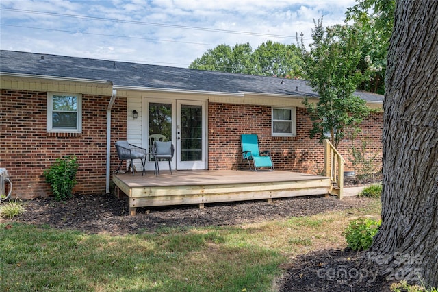 back of house with brick siding and a deck