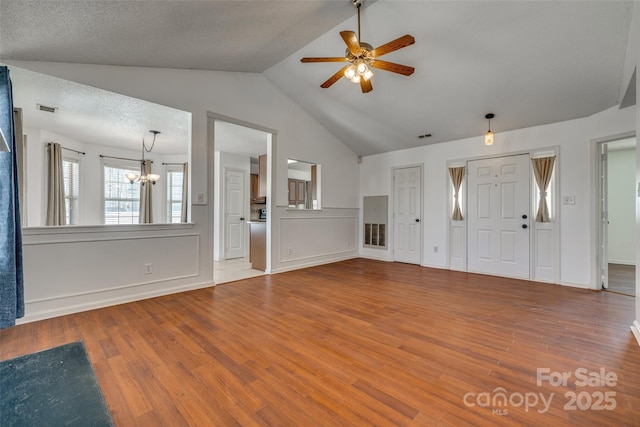 11000 White Stag Dr, Charlotte, NC 28269 - unfurnished living room with a chandelier, wood finished floors, vaulted ceiling, and a ceiling fan