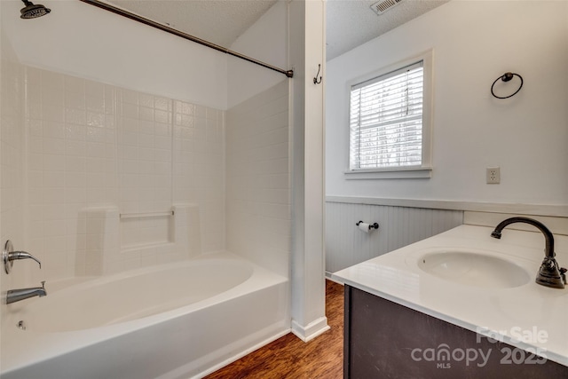 11000 White Stag Dr, Charlotte, NC 28269 - full bathroom with a wainscoted wall, wood finished floors, shower / washtub combination, vanity, and a textured ceiling