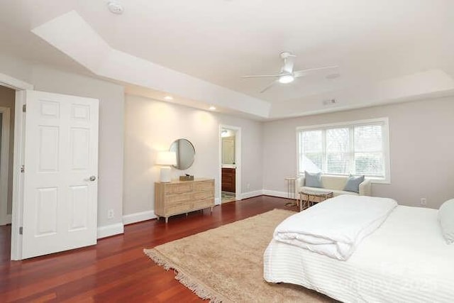 bedroom with baseboards, a tray ceiling, ceiling fan, and wood finished floors