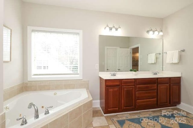 bathroom featuring double vanity, a jetted tub, a sink, and baseboards