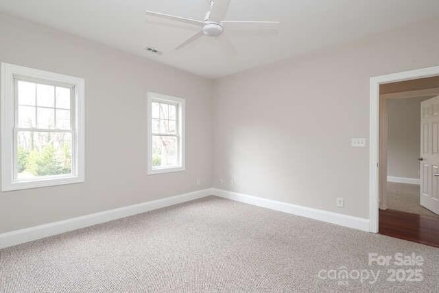 spare room featuring baseboards, visible vents, and a wealth of natural light