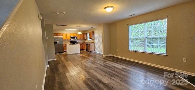 unfurnished living room with dark wood-type flooring and baseboards
