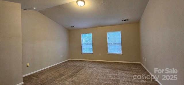 unfurnished room with carpet floors, vaulted ceiling, and baseboards