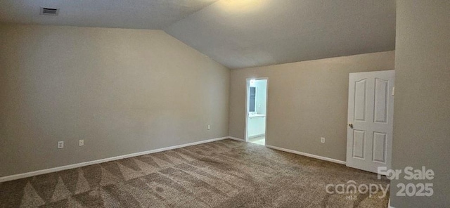 carpeted empty room with lofted ceiling and baseboards
