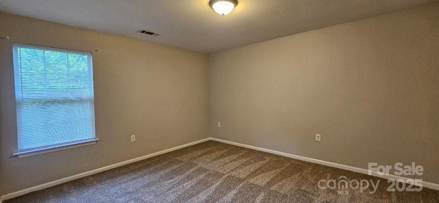 unfurnished room with dark colored carpet and baseboards