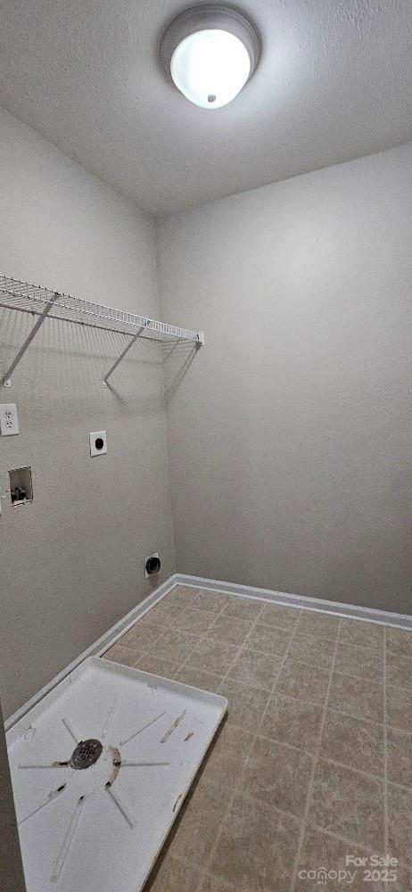 clothes washing area featuring hookup for an electric dryer, hookup for a washing machine, baseboards, and tile patterned floors