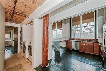 laundry room with laundry area, dark wood-style flooring, a sink, wood ceiling, and washer and clothes dryer