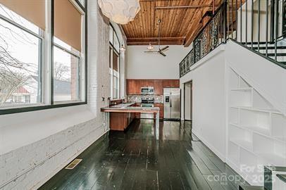 interior space featuring hardwood / wood-style floors, wooden ceiling, stairway, and a towering ceiling