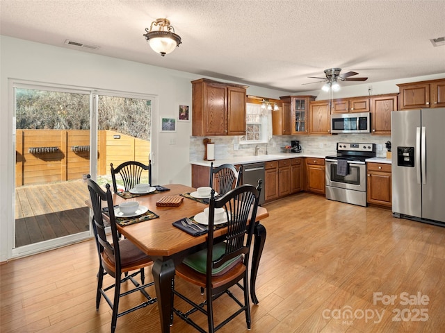 dining room with visible vents, light wood-style flooring, and a textured ceiling