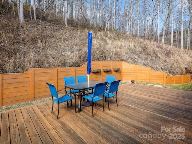 deck featuring outdoor dining space and a fenced backyard