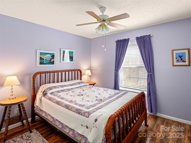 bedroom with a ceiling fan, a textured ceiling, baseboards, and wood finished floors