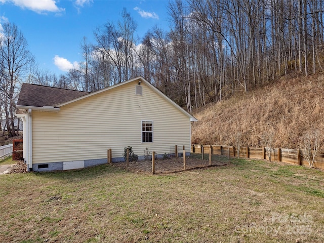 view of property exterior featuring crawl space, roof with shingles, fence, and a lawn