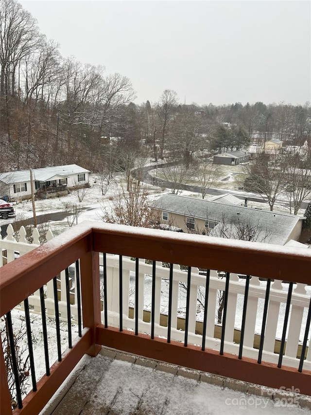 view of snow covered back of property