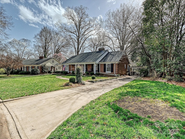 view of front of home with driveway, brick siding, and a front lawn