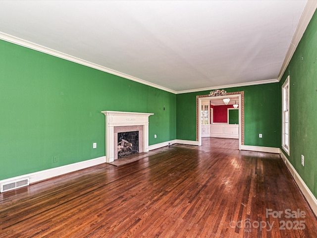 unfurnished living room with a fireplace, visible vents, ornamental molding, wood finished floors, and baseboards