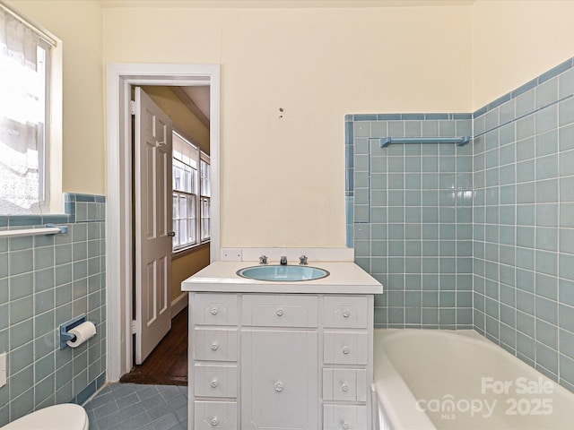 bathroom featuring shower / bath combination, toilet, tile walls, and vanity