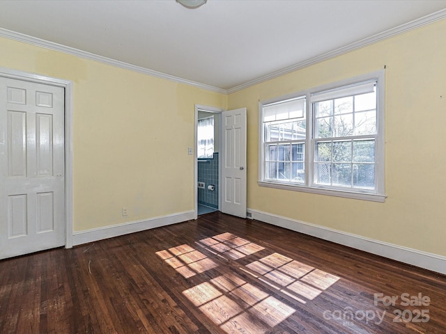 interior space with ornamental molding, dark wood-style flooring, and baseboards