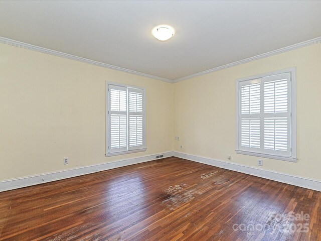 unfurnished room with baseboards, ornamental molding, and dark wood finished floors