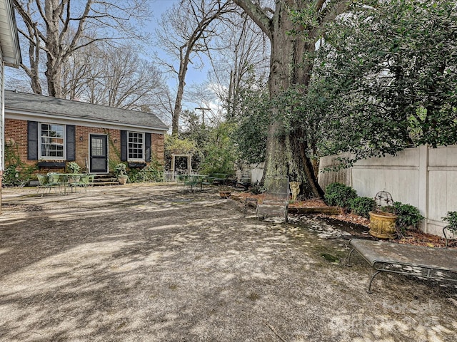 view of yard featuring entry steps and fence