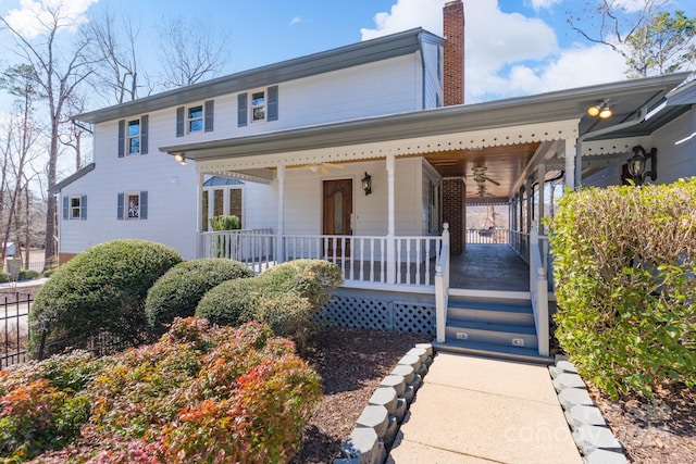 view of front of house featuring a chimney and a porch