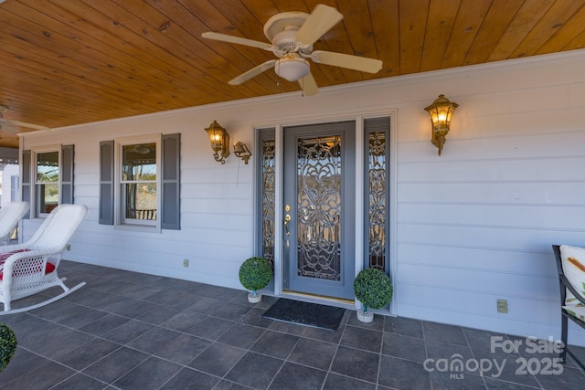 view of exterior entry with covered porch and a ceiling fan