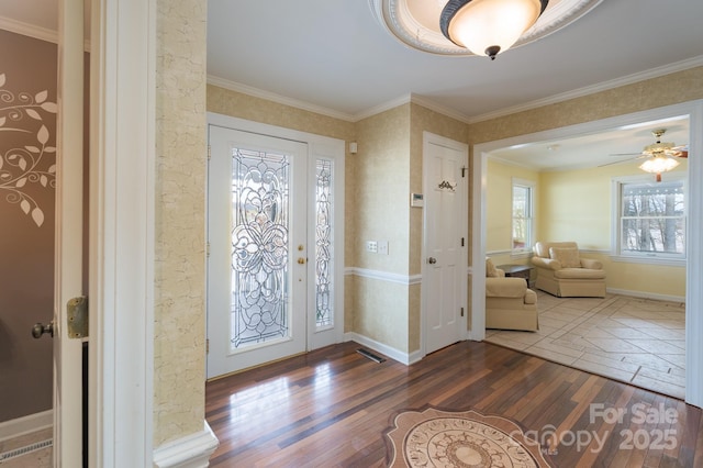 entrance foyer with ornamental molding, baseboards, and hardwood / wood-style floors