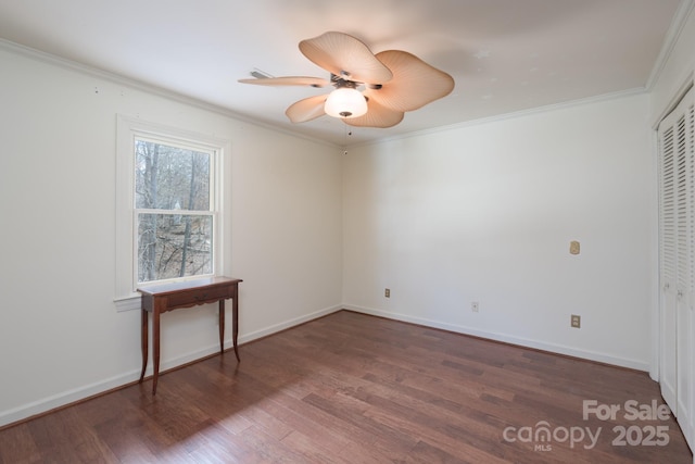 spare room featuring ornamental molding, ceiling fan, baseboards, and wood finished floors