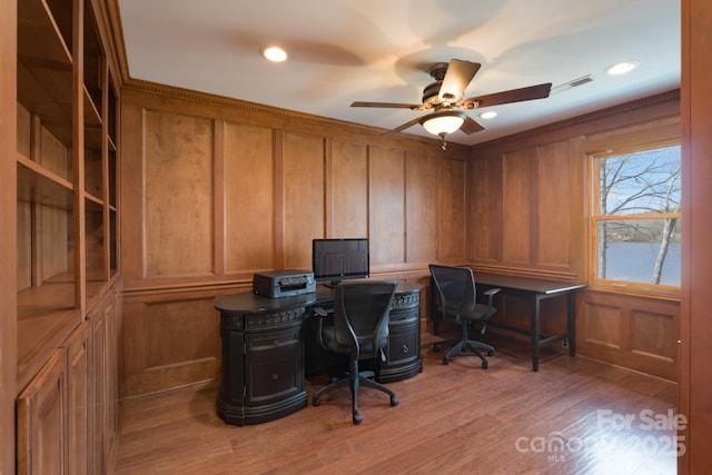 office featuring recessed lighting, visible vents, a decorative wall, ceiling fan, and light wood-type flooring