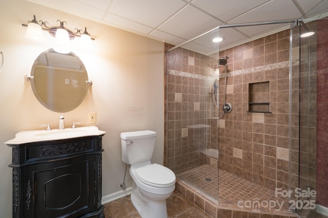 full bathroom with toilet, a stall shower, vanity, baseboards, and tile patterned floors